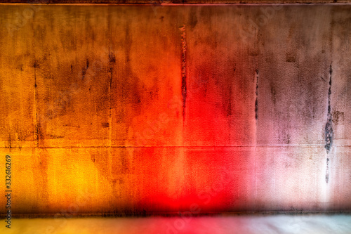 Water falling on a concrete wall on dancing colors