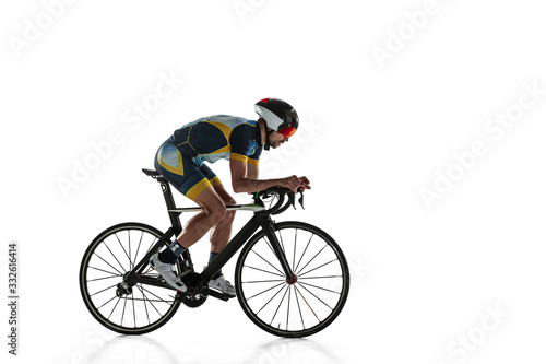 Fototapeta Naklejka Na Ścianę i Meble -  Triathlon male athlete cycle training isolated on white studio background. Caucasian fit triathlete practicing in cycling wearing sports equipment. Concept of healthy lifestyle, sport, action, motion.