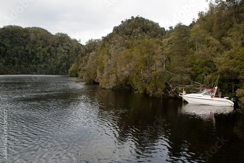 Strahan Tasmania, view along river with small boat docked at wooden  pier