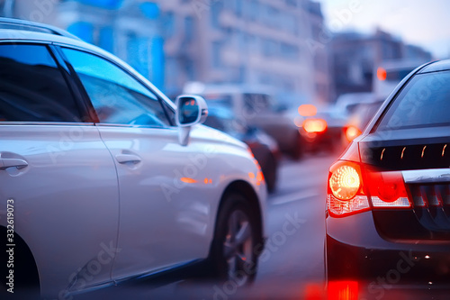 view of car in traffic jam / rear view of the landscape from window in car, road with cars, lights and the legs of the cars night view