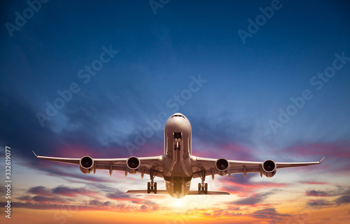 Passengers commercial airplane flying in sunset