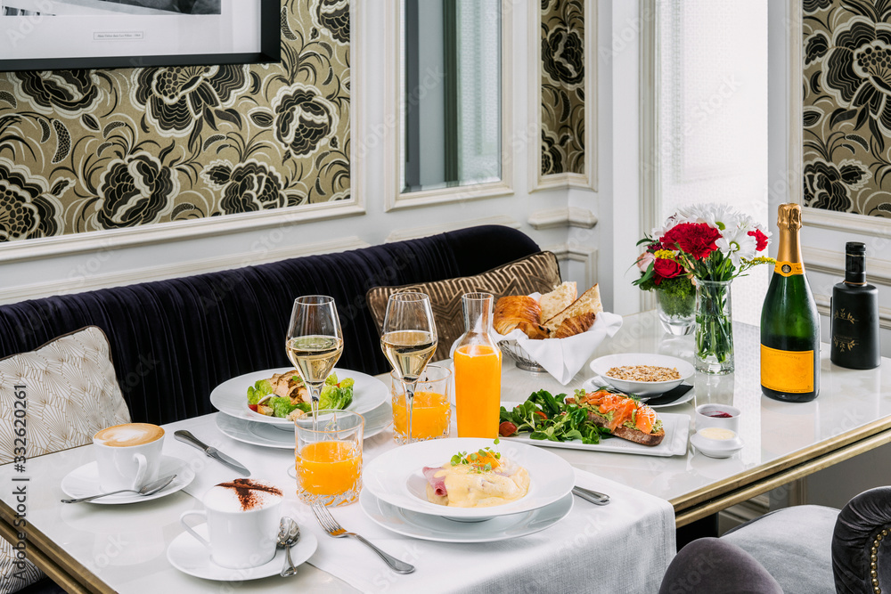 Brunch with poached eggs, fruit, orange juice and cava