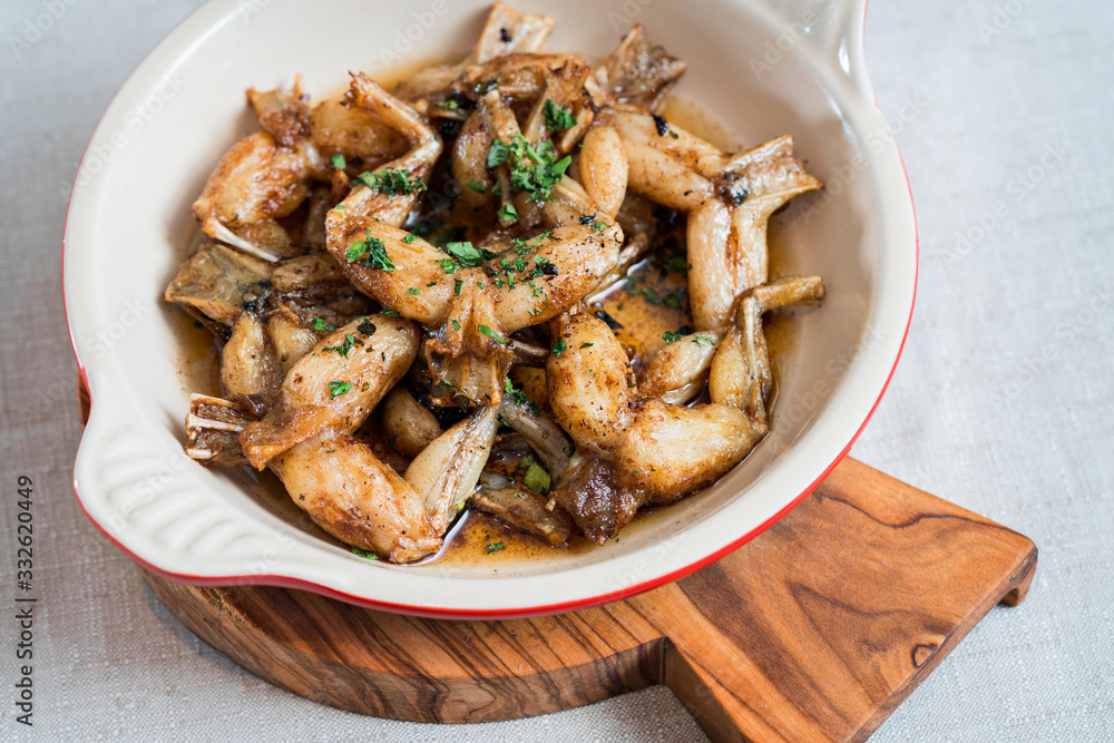 Fried frog legs on a wooden board