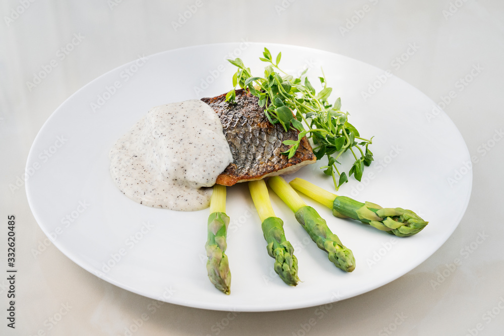Hake with black pepper sauce accompanied by asparagus Hake with black pepper sauce accompanied by asparagus