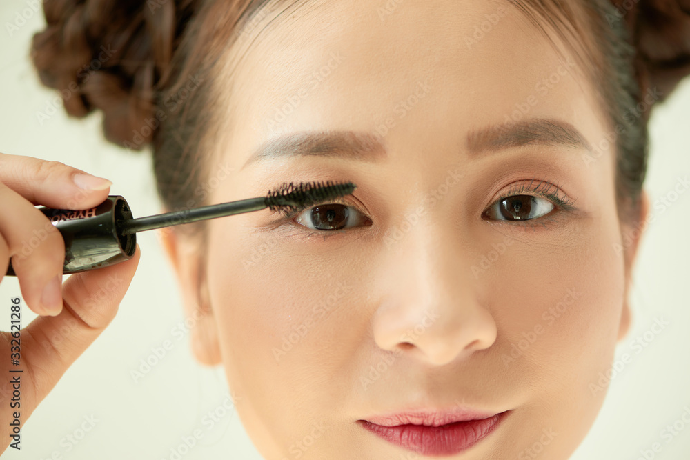 beautiful young woman applied mascara, studio beauty portrait