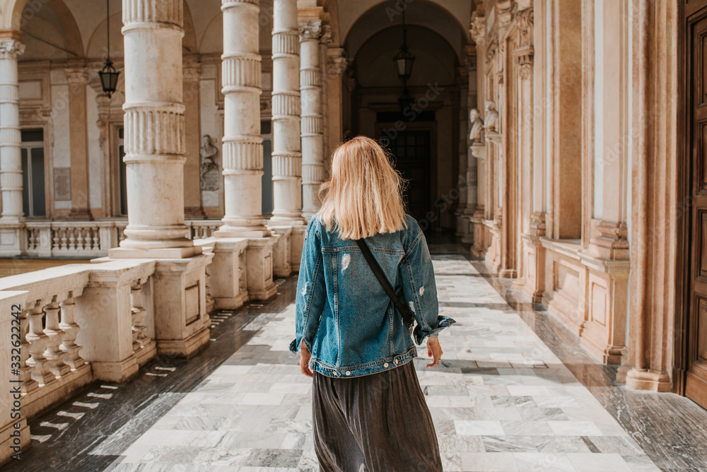 A beautiful woman with blond hair walks through the streets of the city. Girl enjoy holidays in Europe. Beautiful historical architecture. Italian weekend. Travel to Turin, Italy. Adventure lifestyle