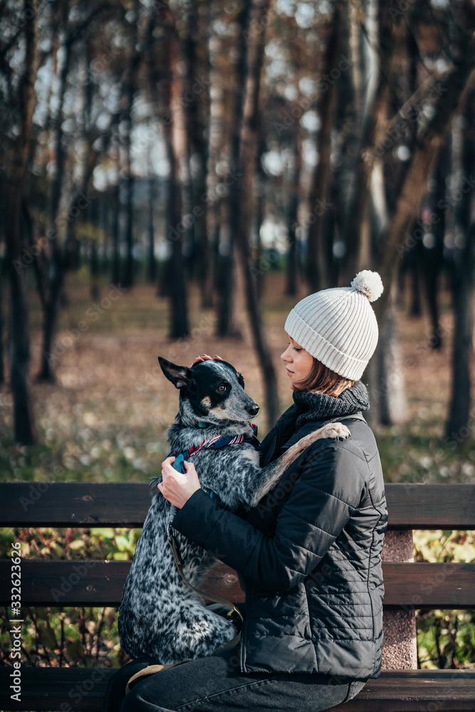 Fototapeta premium A girl is holding a mongrel dog in her arms. Caring for animals.
