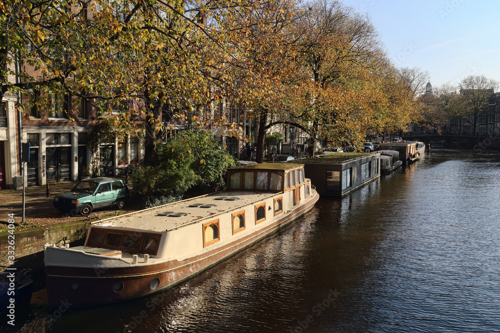 Fototapeta premium Canal with house boats in Amsterdam, Holland
