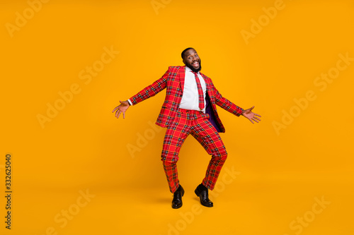 Full size photo of crazy dark skin guy dance youth moves bachelor men stag party enjoy popular song wear plaid red costume blazer pants shoes isolated yellow color background © deagreez