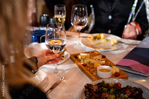 people hands with glasses of wine at holiday table