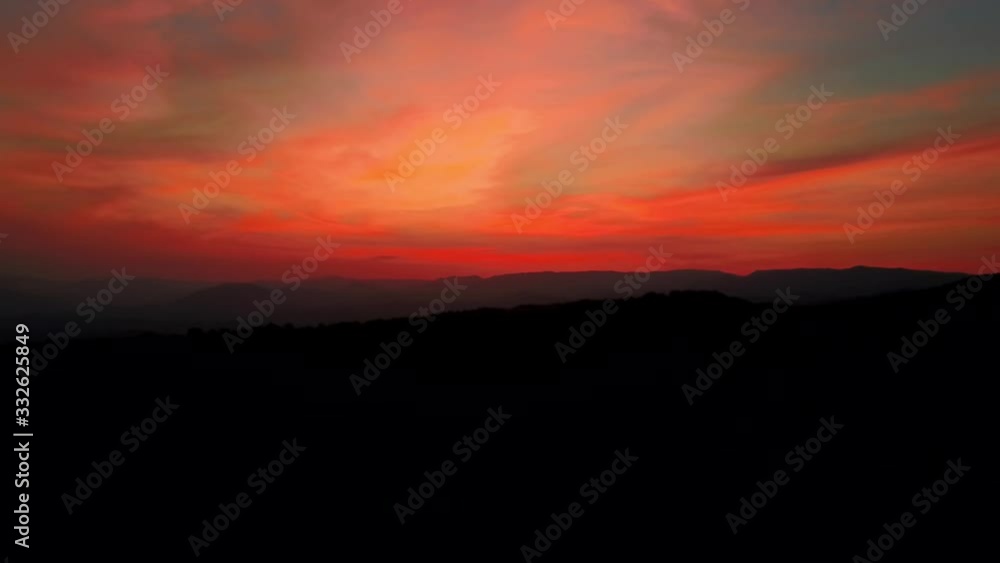 Aerial colorful fire sunset over black mountains pink red and orange Aerial colorful fire sunset over black mountains pink red and orange