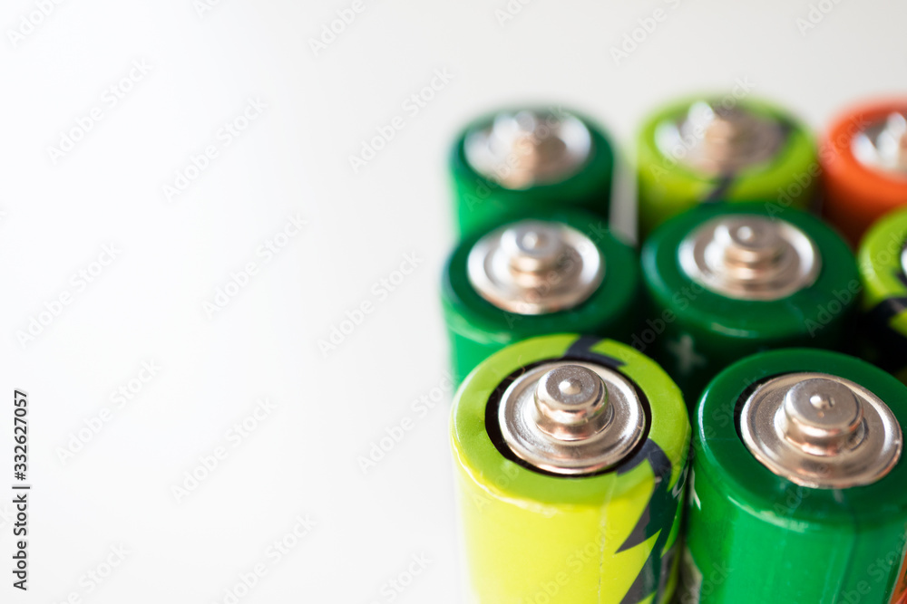 Various alkaline batteries on white background with selective focus. Concept waste sorting and environmental pollution Various alkaline batteries on white background with selective focus. Concept waste sorting and environmental pollution