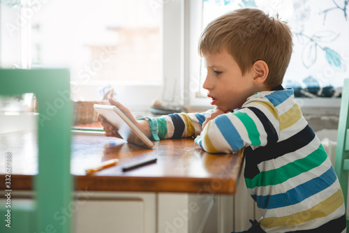 Young Boy looking at digital tablet, staying at home