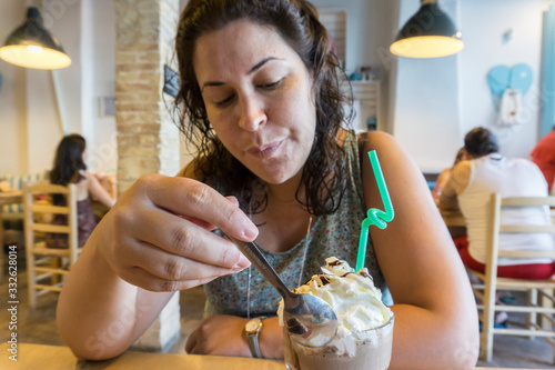woman eating a smoothie with cream