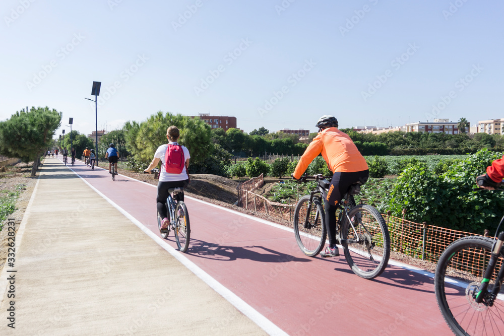 Meliana, Spain, 3,7,2015:cyclists down the bike path in the middle of the orchards