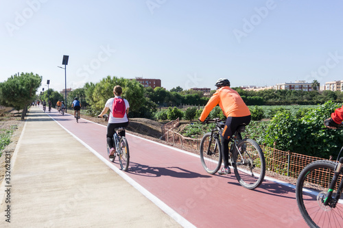 Obraz na płótnie Meliana, Spain, 3,7,2015:cyclists down the bike path in the middle of the orchards w salonie