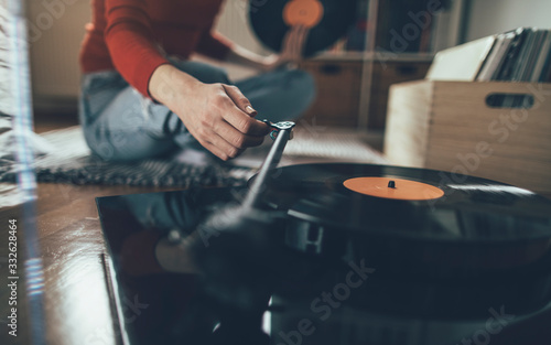Принти на полотні Close up of female hand hold tonearm and play vinyl record on turntable