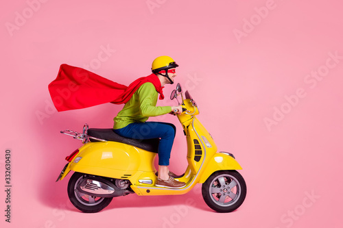 Profile side view of his he nice attractive cheerful cheery purposeful guy driving moped fast wearing cape mantle rescuing people isolated over pink pastel color background © deagreez
