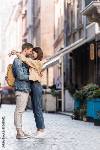 Happy boyfriend and girlfriend hugging in city