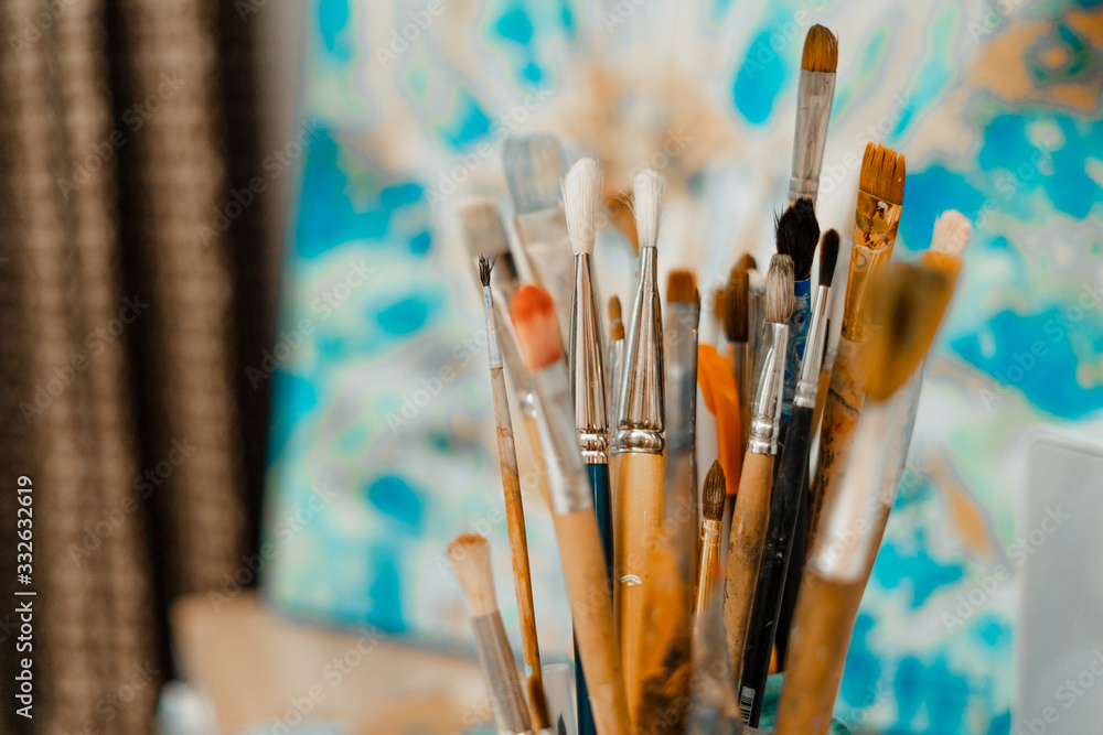 Obraz premium Tools and equipment for the artist. Palette and brushes close-up. The process of drawing and creativity. The picture is in blue.