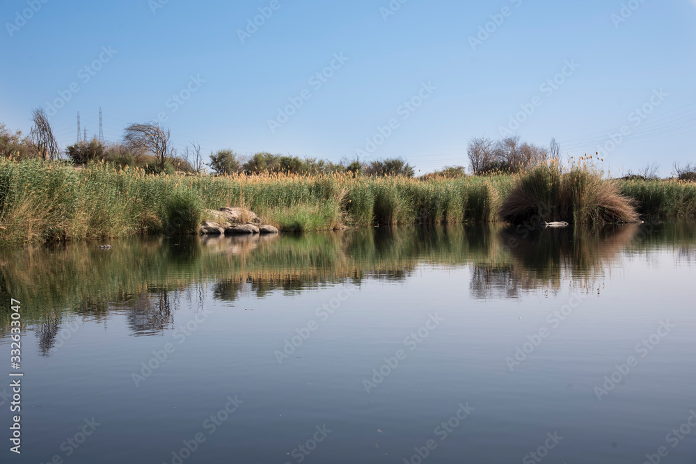 Entrance of the Nile River as it passes through the Nubian People in Aswan, Egypt, Afriaca. Amazing landscape of water and vegetation next to the desert.