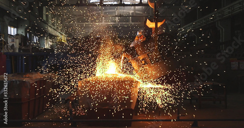 The molten metal is poured into the mold. Melting furnace for cast iron and steel and liquid metal. photo