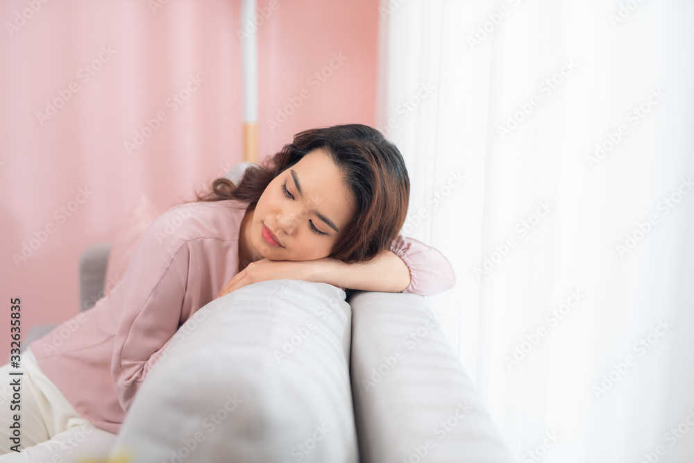 Thoughtful girl sitting on couch at home. Thoughtful girl sitting on couch at home.