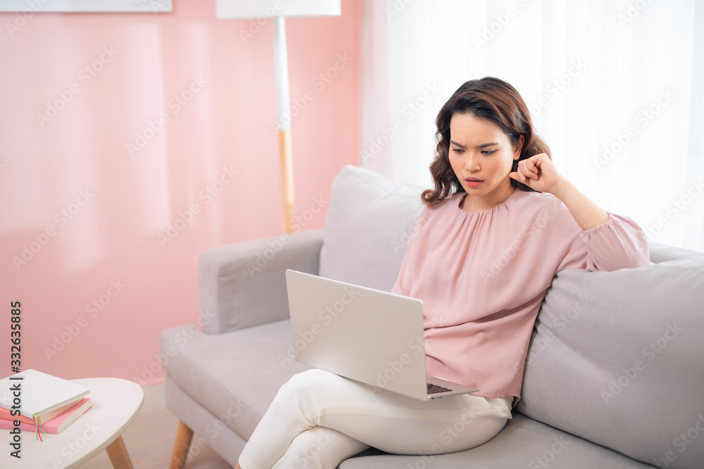 Asian woman seem nervous when using laptop at home. Asian woman seem nervous when using laptop at home.