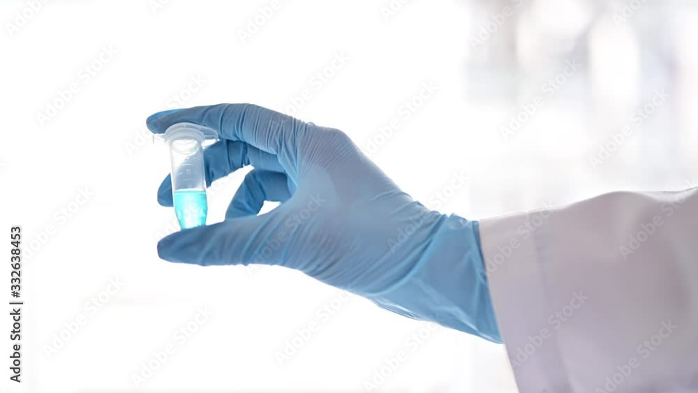 液体の入ったチューブを持つ研究員 液体の入ったチューブを持つ研究員