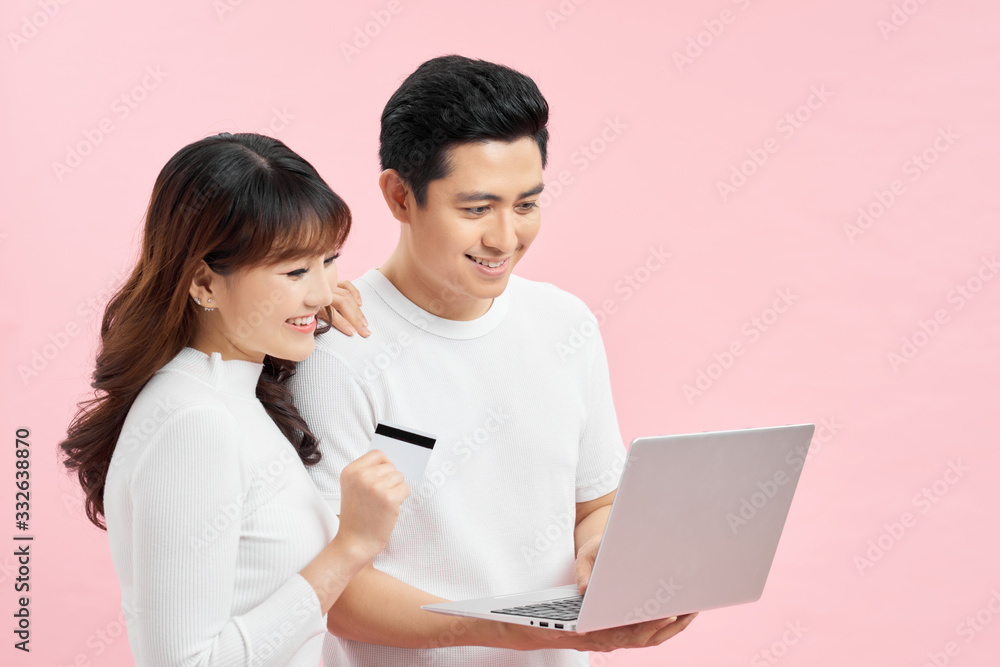 happy attractive smiling couple man and woman with credit card and laptop happy attractive smiling couple man and woman with credit card and laptop