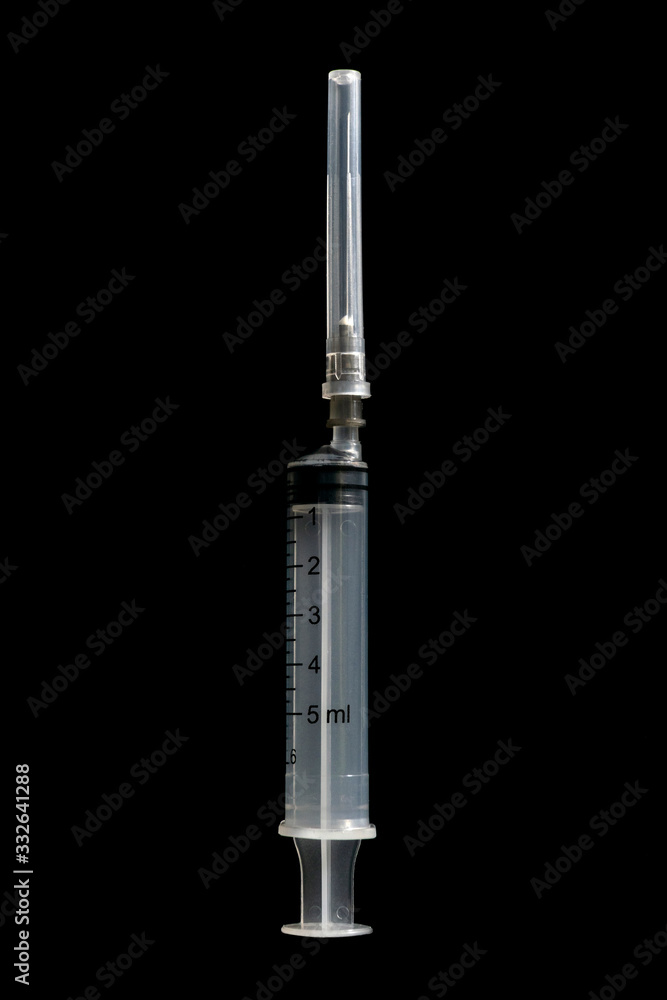 Medical syringe with protective cap isolated on black background. Medical syringe with protective cap isolated on black background.