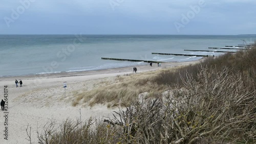 Aerial view from coast cliff of Ahrenshoop Baltic sea down to beach. People walking along.