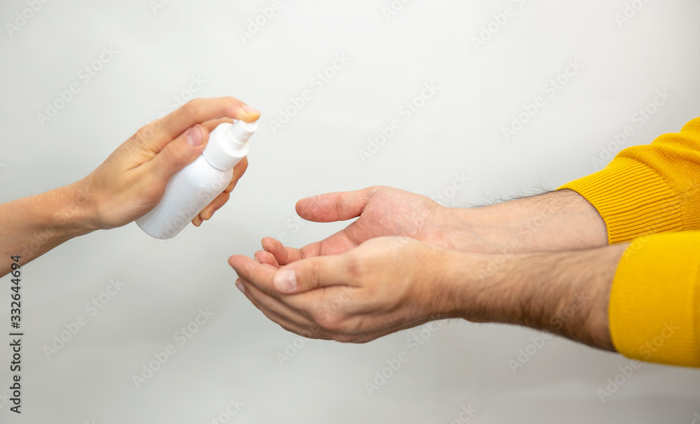 Hand disinfection masked young man.