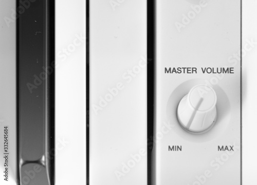 master volume control on piano and button on and off on device, white piano and keys, gray color band on potentiometer control, logo of power controller