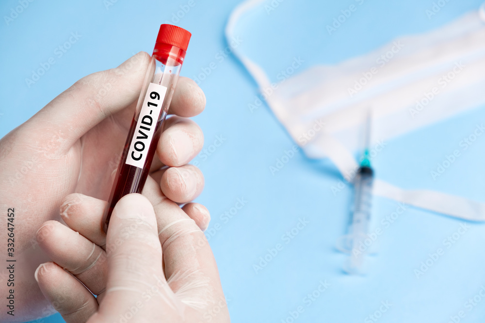 Naklejka premium Doctor holding test tube with blood for 2019-nCoV analyzing. Coronavirus disease COVID-19 pandemic
