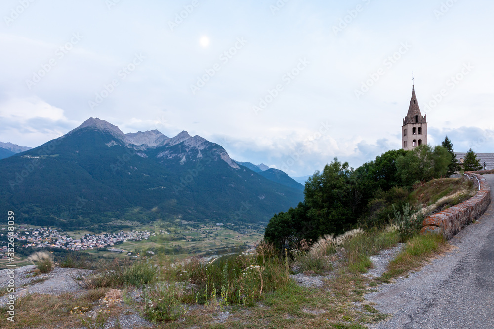 Landscape view with Alps mountains and antique church. Town under mountains in valley. Puy-Saint-Pierre, France, Europe.