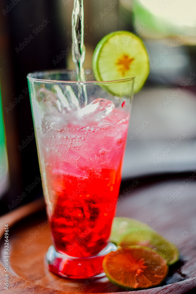 red juice water whit soda and lemon in glass on wood table at cafe. Summer drink red juice water whit soda and lemon in glass on wood table at cafe. Summer drink