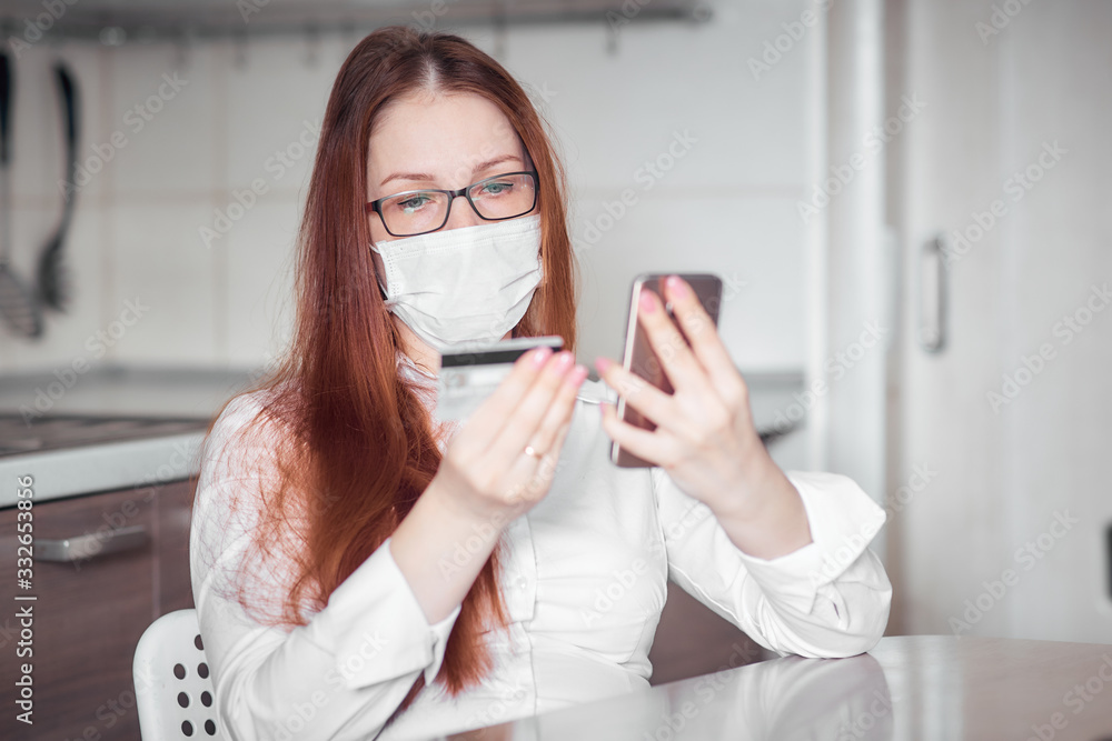 ordering food and medicine in an online store during the quarantine and epidemic, portrait of a woman in a medical mask ordering food and medicine in an online store during the quarantine and epidemic, portrait of a woman in a medical mask