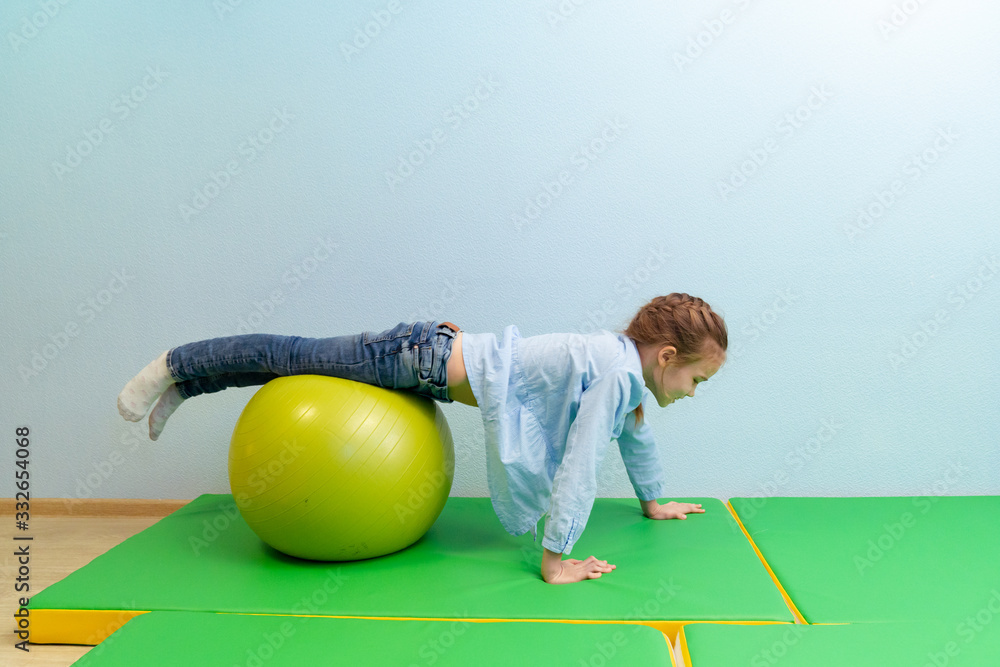 teen girl engaged in physical therapy on ball - obrazy, fototapety, plakaty 