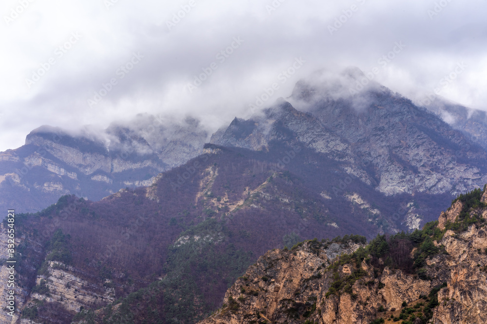 Mountains with fog and clouds above them.