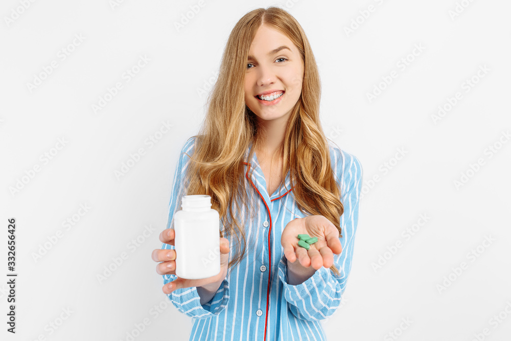 A girl in pajamas holds a white plastic pill jar, a concept for medical treatment of diseases, a close-up of a white pill jar A girl in pajamas holds a white plastic pill jar, a concept for medical treatment of diseases, a close-up of a white pill jar