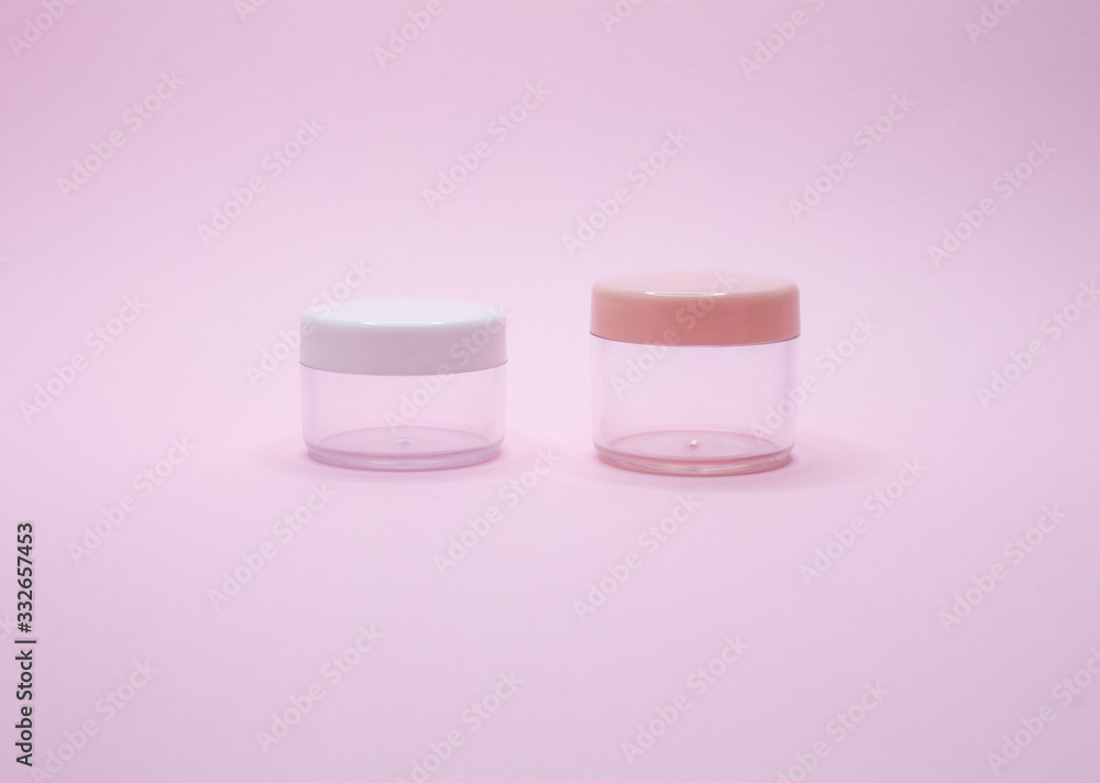 Two empty cosmetic jars on pink background Two empty cosmetic jars on pink background