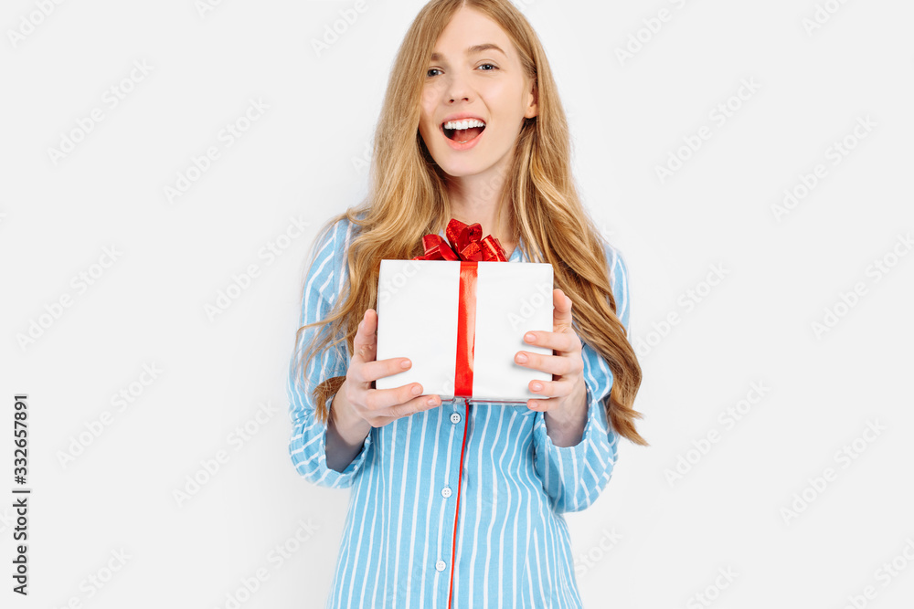 Beautiful girl in pajamas, with a gift in her hands , on Valentine's day, or mother's day, a gift from a loved one Beautiful girl in pajamas, with a gift in her hands , on Valentine's day, or mother's day, a gift from a loved one