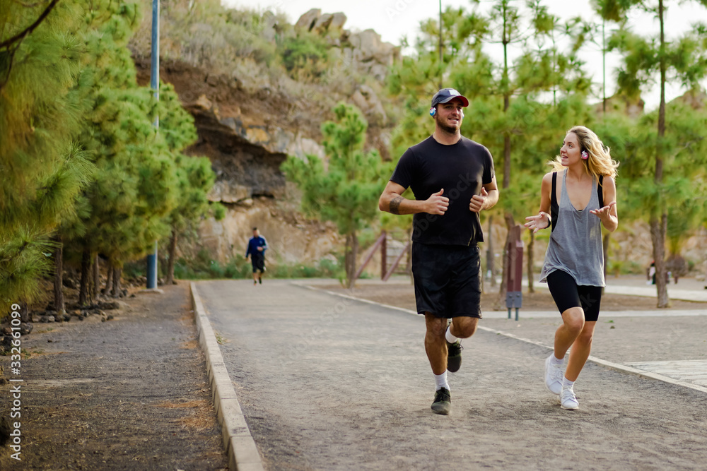 Obraz premium Young people running outdoors. Friends running in the park. Couple of runners on morning run. Jogging, healthy lifestyle and sport concept - Image.