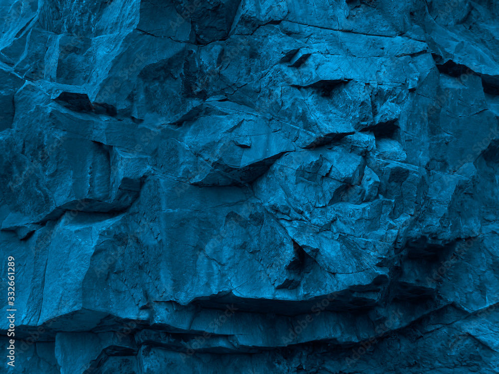 Fototapeta premium Blue grunge background. Toned rock texture. Fragment of a mountain close-up. 3D effect. Petrol color combinations with rough stone texture. Modern bright grunge background.