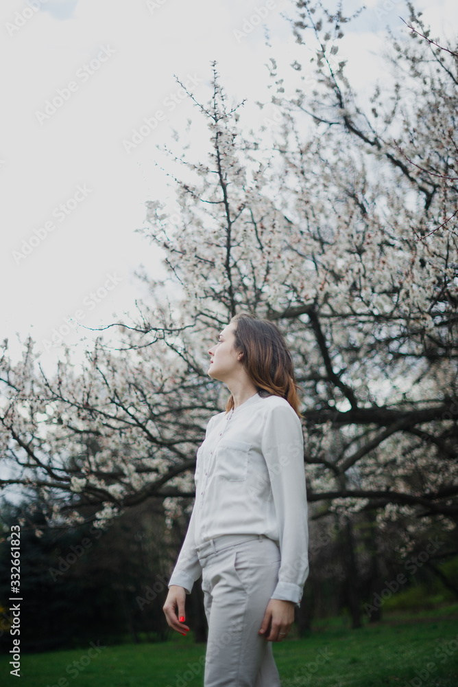 Beautiful young girl is resting and enjoying spring in the spring park Beautiful young girl is resting and enjoying spring in the spring park