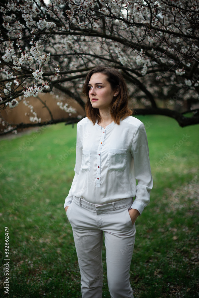 Beautiful young girl is resting and enjoying spring in the spring park Beautiful young girl is resting and enjoying spring in the spring park
