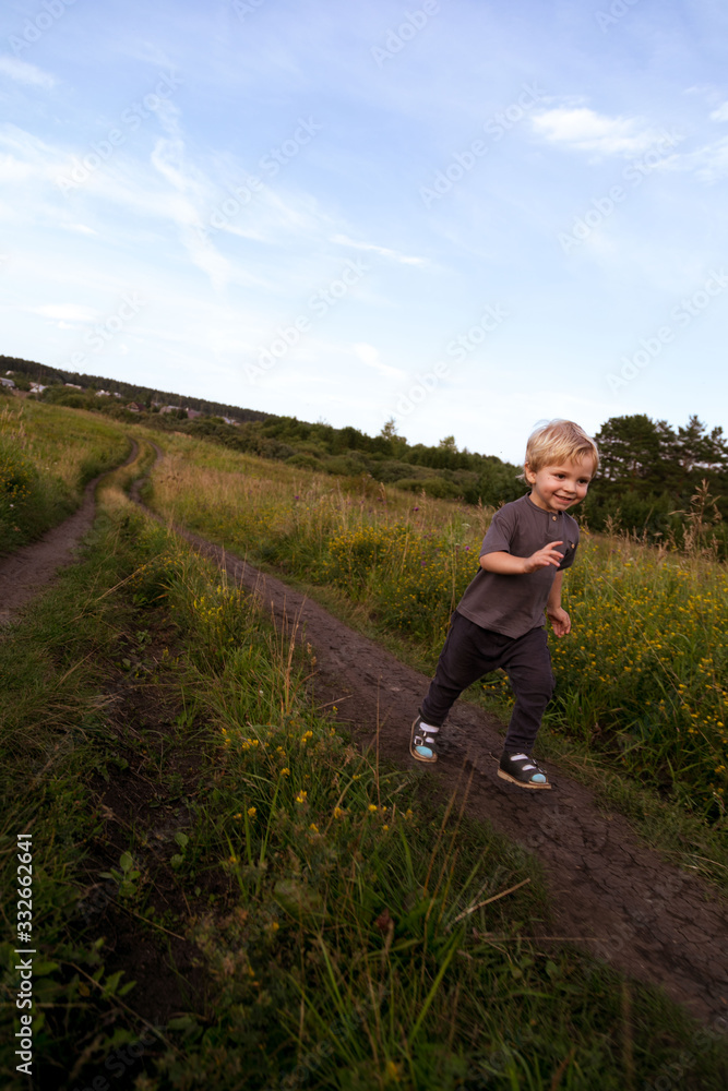 Happy little boy running across the field Happy little boy running across the field