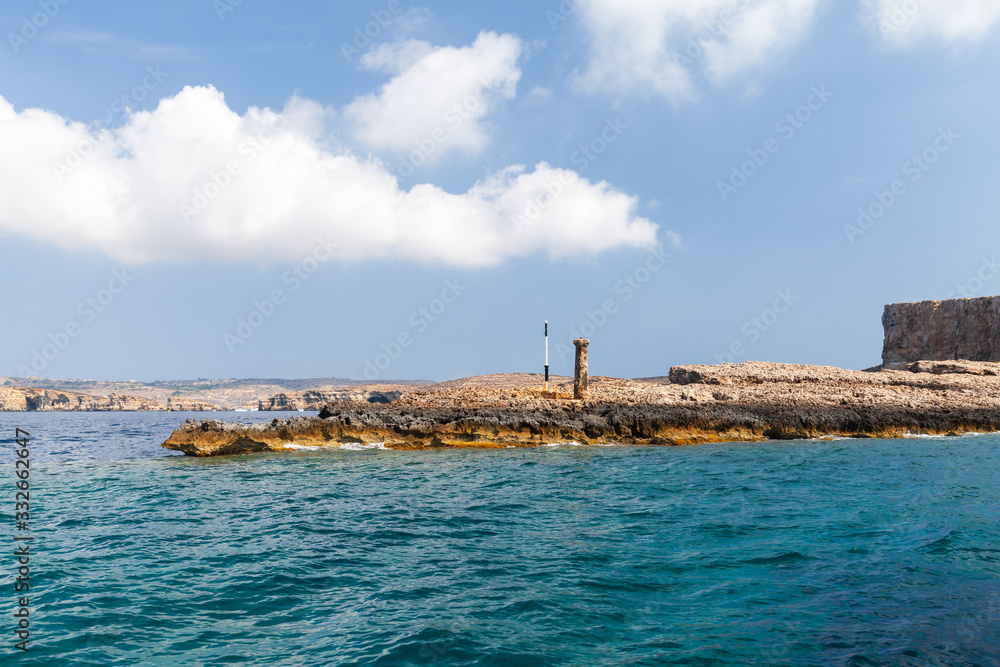 Beacon on a rocky coast of Comino island, Malta