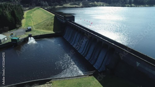 Low level aerial footage over a reservoir and dam revealing a scenic Scottish landscape on a bright Spring day.